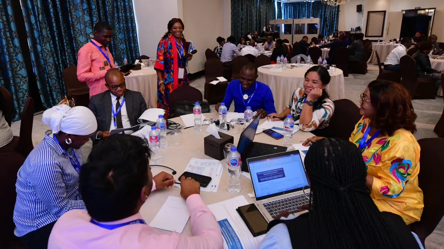 Participants sit around a conference table during an interactive group discussion.