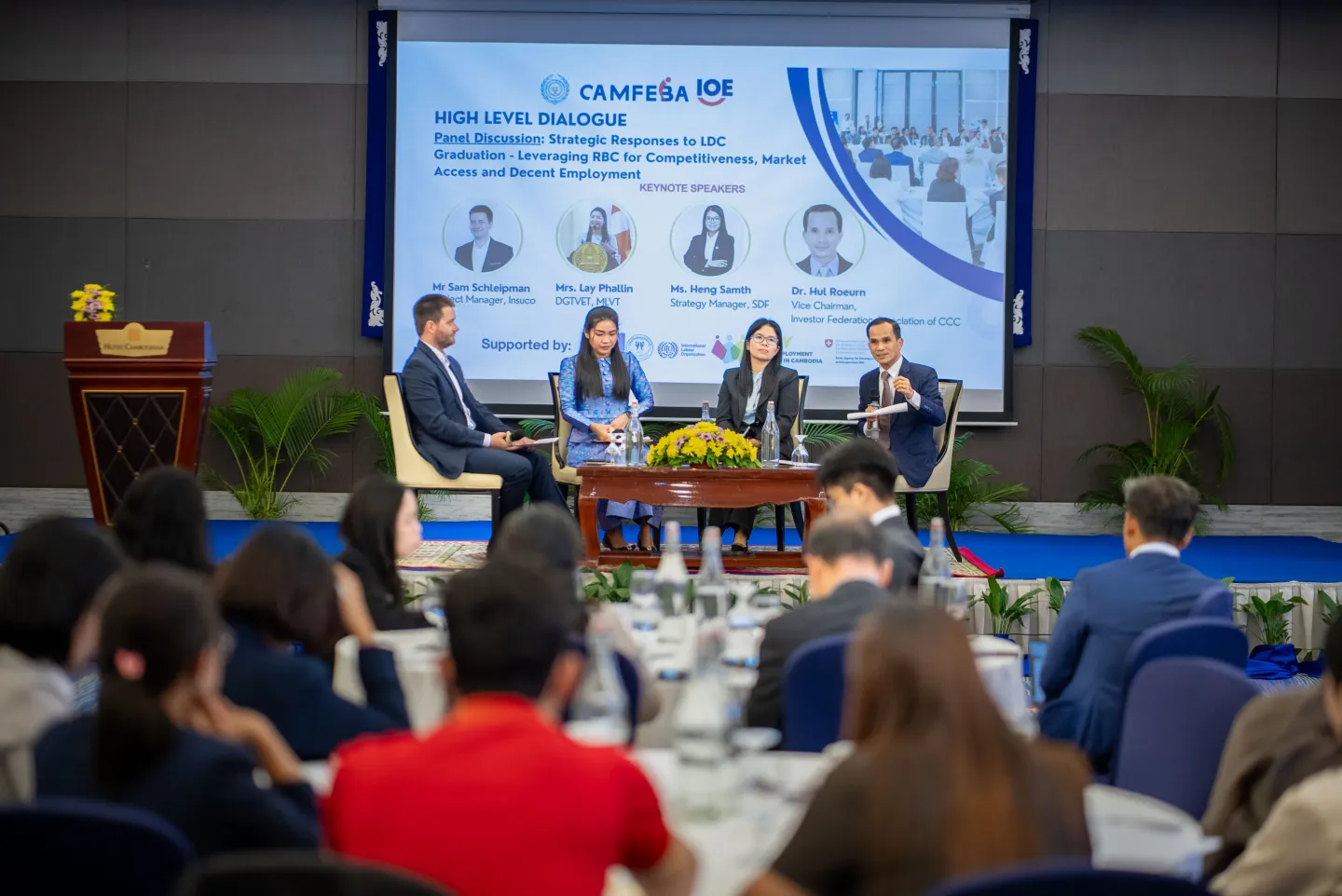 our speakers participate in a panel discussion, as an audience listens.