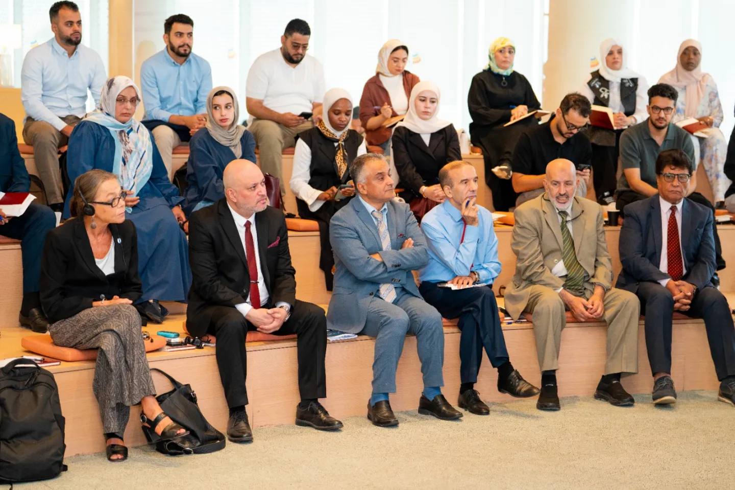 A diverse group of participants seated in an auditorium listens to presentations during an entrepreneurship ecosystem workshop in Tripoli, Libya.