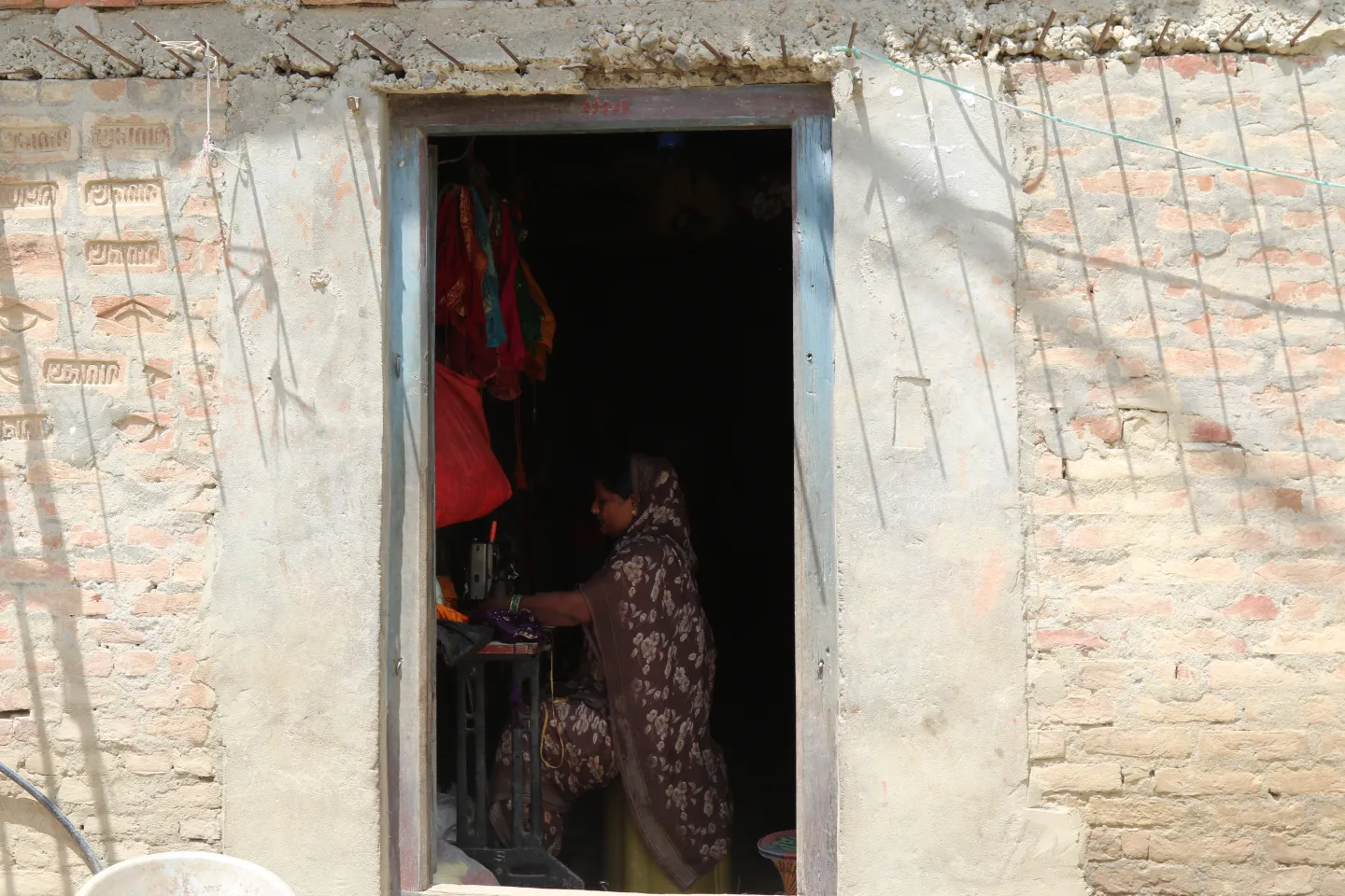 Jayamala at work in her home, putting her tailoring skills into practice and building a livelihood of her own.
