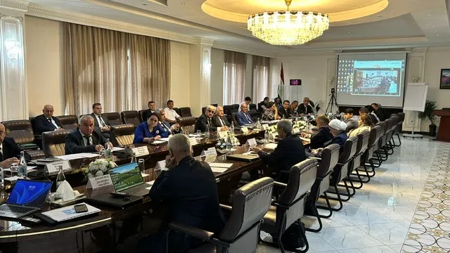 Group of people sitting around a long conference table