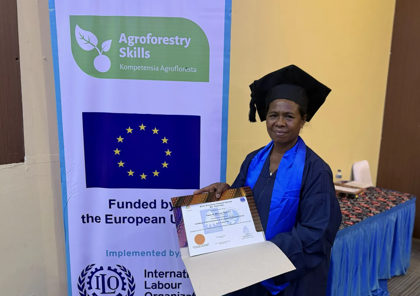 Clara Moreira holds her certificate after graduating from competency-based trainer training in Dili, Timor-Leste.
