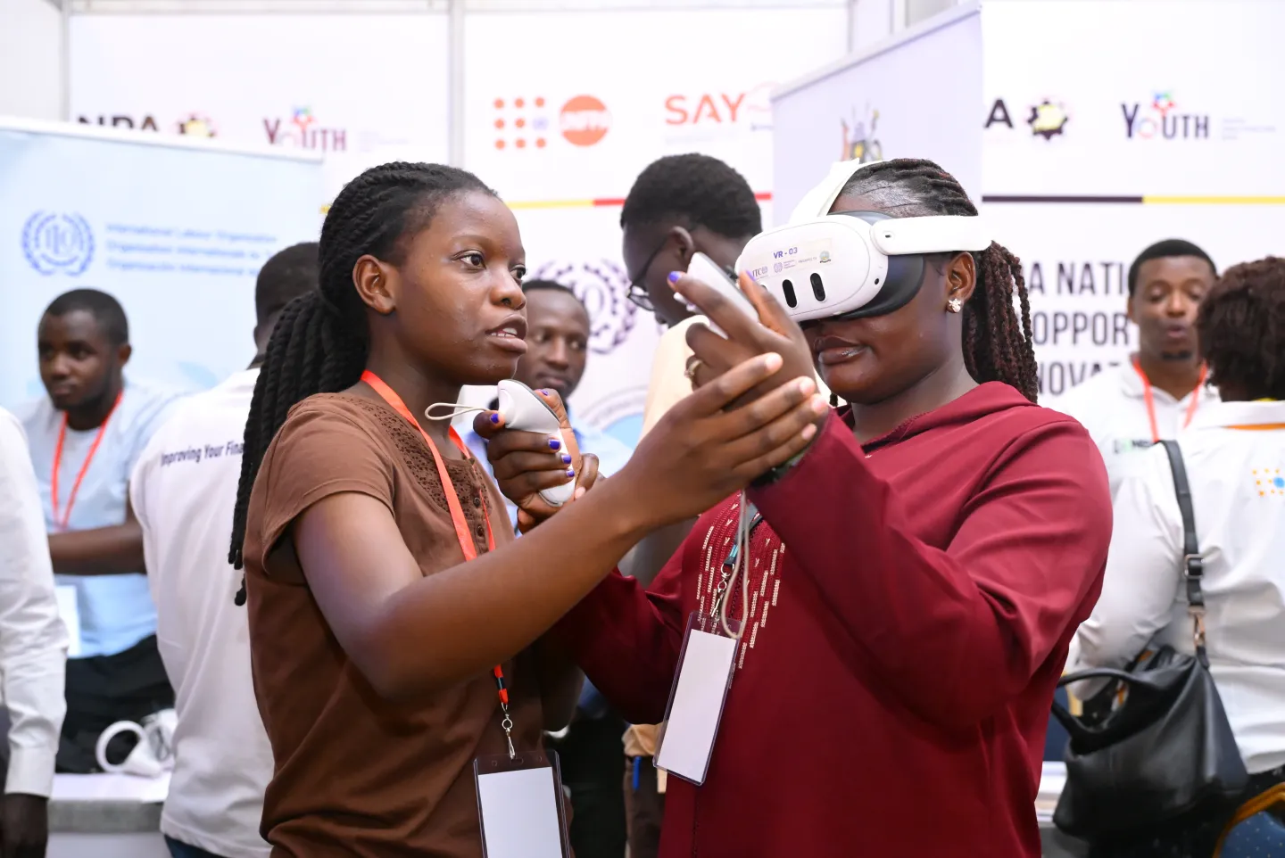 a trainer woman helping an event participant to operate virtual reality equipment