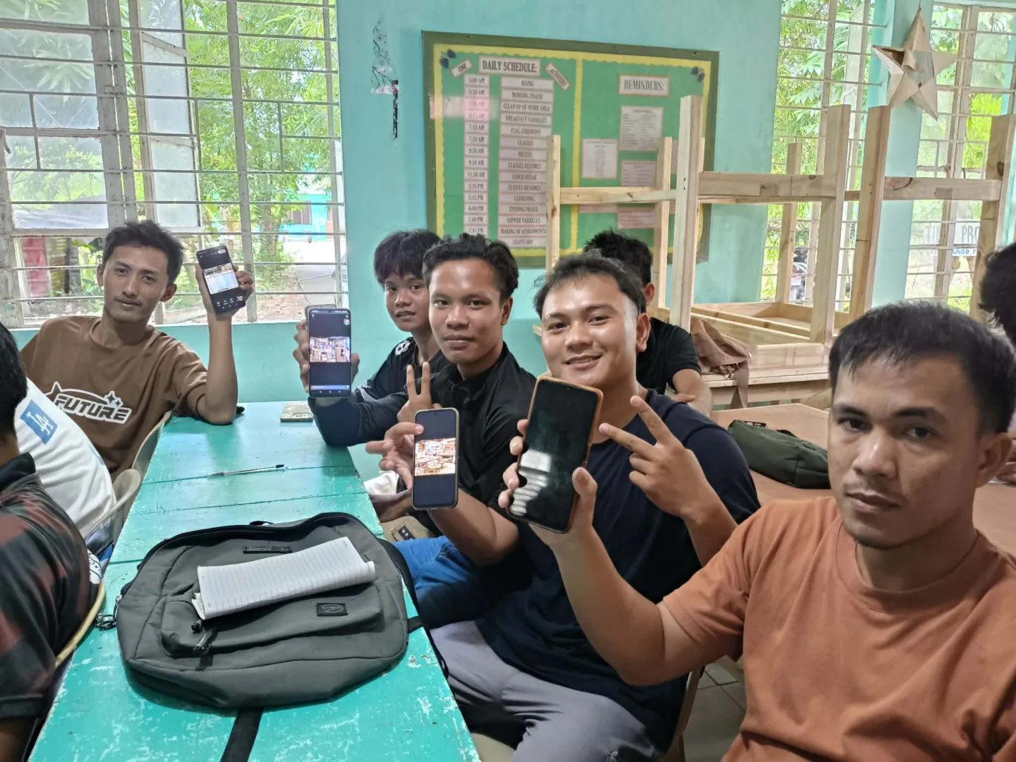 TESDA students hold up mobile phones during an AI learning activity.