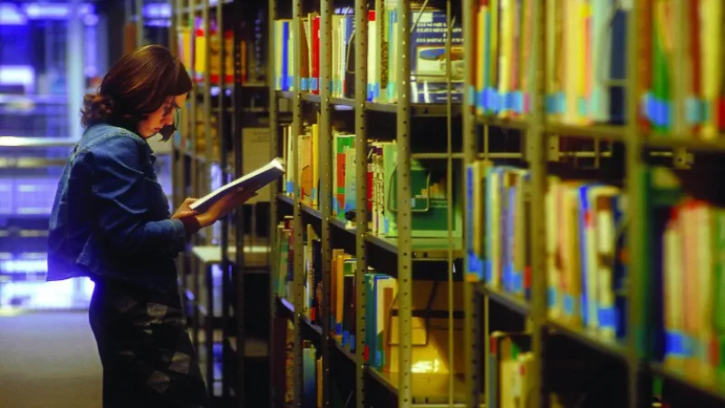 A person reading a book at a library