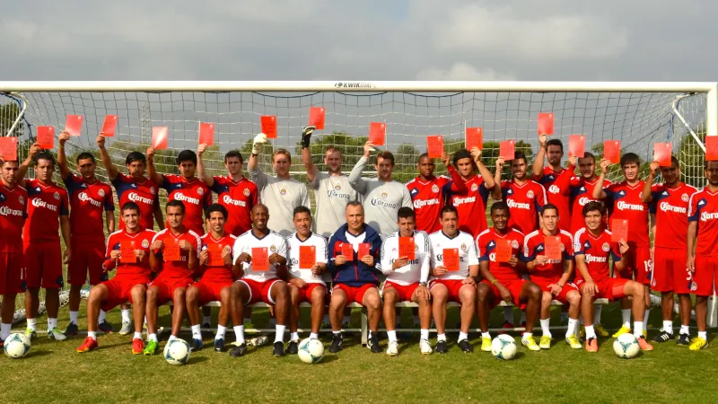Chivas US Football team holding Red cards against child labour
