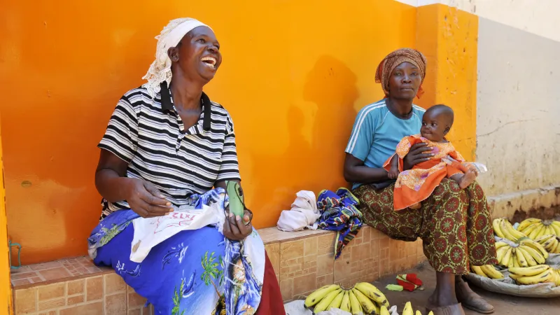women with a baby selling bananas