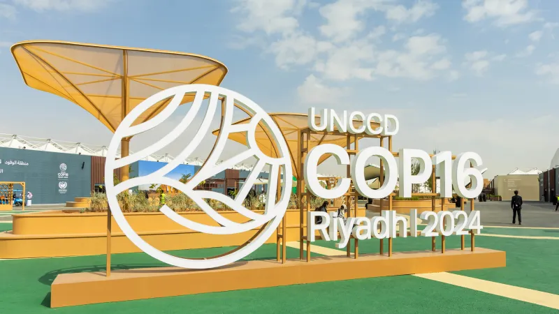 The iconic COP16 Riyadh 2024 logo stands tall, set against a backdrop of innovative design and greenery, welcoming visitors from across the world.