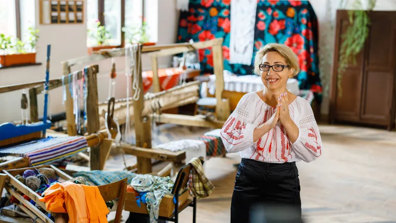 Ms. Aurica Cazacu working with a sewing machine in her embroidery workshop in Moldova.