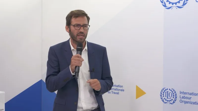 A speaker holding a microphone at an ILO event.