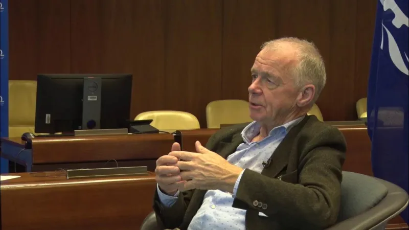 An interview participant speaking in a conference room.